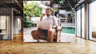 Happy man watching videos on laptop Wall mural