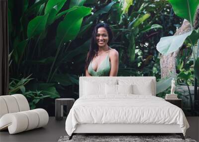 Happy woman in provocative dress standing in tropical garden Wall mural