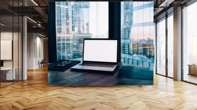 Image of modern working space with equipment and panoramic windows in office interior, open laptop computer with mock up screen and contemporary software for job standing on wooden table Wall mural