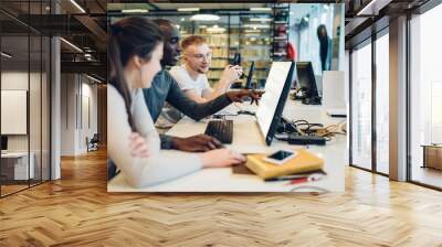 Interested multiracial students using computer while studying in library Wall mural