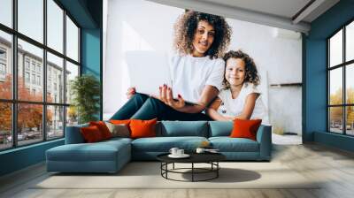 Loving mother and daughter sitting with laptop Wall mural