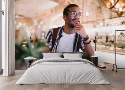 Pensive ethnic man with tablet in cafe Wall mural