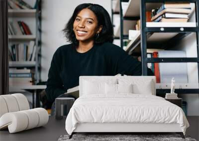 portrait of cheerful african american girl smiling satisfied with interesting book find in college l Wall mural