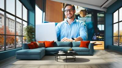 Portrait of cheerful businessman completing work on startup satisfied with making great job Wall mural