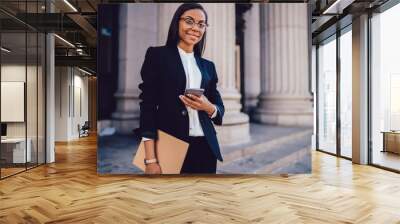 portrait of successful african american businesswoman dressed in stylish suit holding in hand folder Wall mural