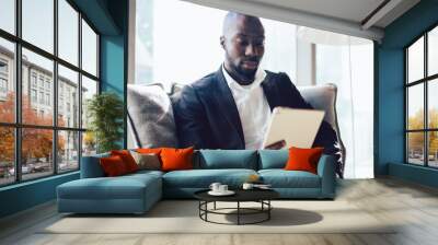 Serious black businessman using tablet Wall mural