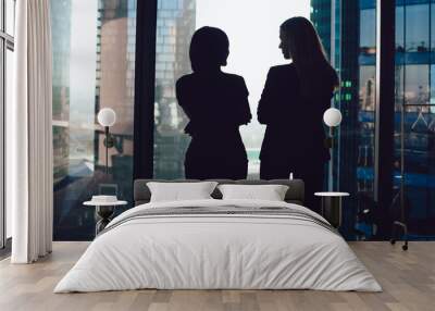 Silhouettes of businesswomen in modern office near window Wall mural