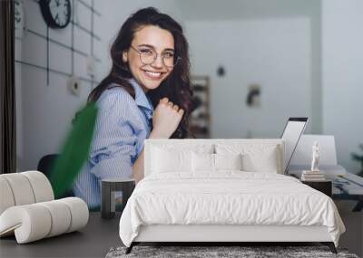 Smiling female studying at laptop in classroom Wall mural