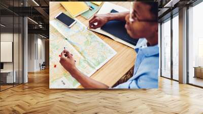 Top view of african american hipster guy pointing on destination on map planning journey vacations Wall mural