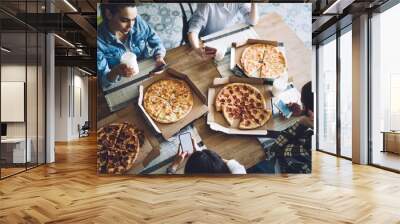 Variety of pizza on table for friends surfing smartphone Wall mural