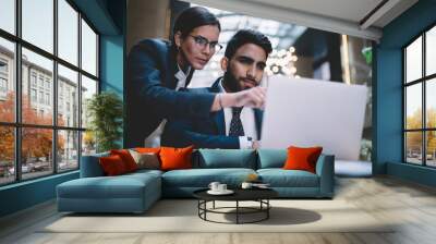 Woman pointing on screen working with colleague at table with laptop Wall mural