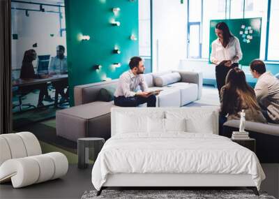 Work partners having conversation in modern hall of workplace Wall mural