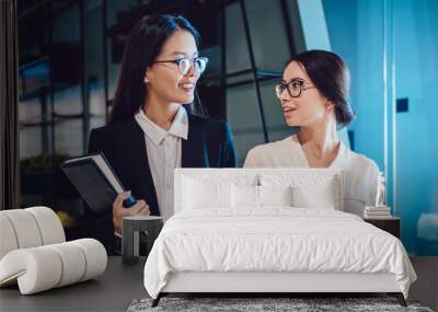 Young chatting female colleagues in office Wall mural