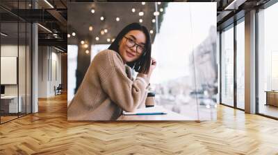 Young millennial asian girl resting in cafe Wall mural