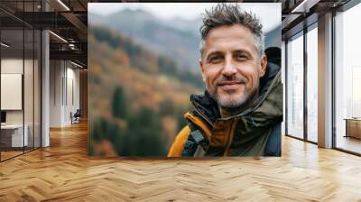 Male portrait of mature individual in scenic terrain of mountains and forests, with a happy expression in the winter months Wall mural