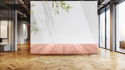 Empty wood table top and blurred white wall in garden background with Green leaves - can used for display or montage your products. Wall mural