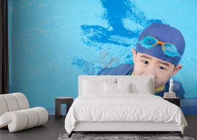 Boy wearing goggles on the edge of the pool. Summer children's sports activity with a parent. Learning and relaxation concept. Just rest after swimming.. Wall mural