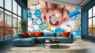 Mother and child hand holding jigsaw puzzle. Home puzzle game. Autism awareness. Mental health care concept with jigsaw pattern supported by family caregiver parent. Family and parent concept Wall mural