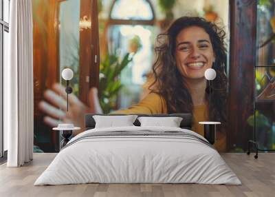 Cheerful woman inviting people to enter in home Wall mural