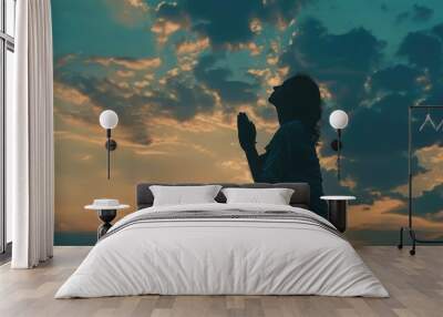 Silhouette of woman kneeling down praying for worship God at sky background. Christians pray to jesus christ for calmness. In morning people got to a quiet place and prayed. copy space Wall mural