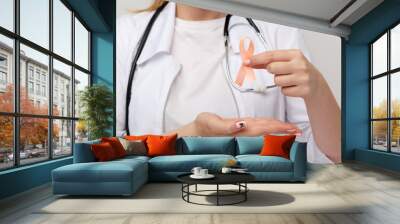 Orange ribbone in doctor's hand isolated Wall mural