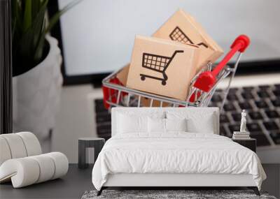 paper boxes in a shopping cart on a laptop keyboard. Concepts about online shopping that consumers can buy things directly from their home or office just using a few clicks via web browser. Wall mural