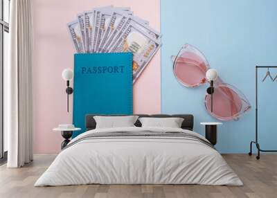 Pink sunglasses and passport with money on blue pink background. Travel, summer vacation or tourism concept. Wall mural