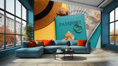 Planning honeymoon traveling concept. Passports with money, tourist hat and shells close-up on a blue yellow background. Wall mural