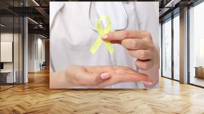 Yellow ribbon in doctor's hand isolated Wall mural