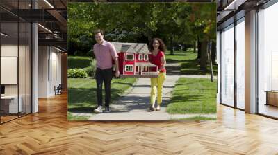 Young couple moving a dollhouse, horizontal Wall mural