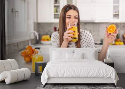 Close up Attractive Sensual Bare Woman drinking juice while Holding Sliced Orange Fruit. Wall mural