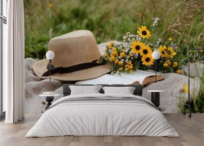 Rustic picnic setup with straw hat, book, and wildflowers for outdoor relaxation and spring inspiration Wall mural