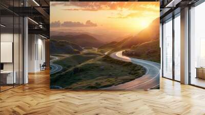 A curvy road winds through the mountains in sunset Wall mural