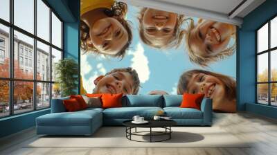 Bunch of cheerful joyful cute little children playing together and having fun. Group portrait of happy kids huddling, looking down at camera and smiling. Low angle, view from below. Friendship concep Wall mural