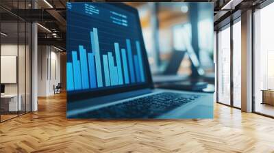 Business financial growth trends displayed in blue bar charts on financial documents the background is a laptop on a work desk in the office. Wall mural