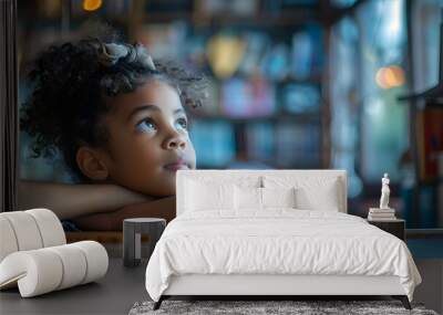 A young girl with curly hair is looking out the window Wall mural