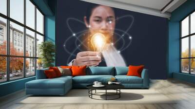 Business Asian woman Holding Illuminated Light Bulb with innovative and creativity are keys to success,innovation and inspiration,ideas and inspiration. concept Wall mural