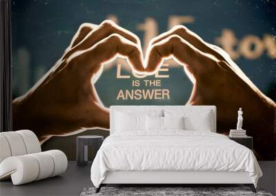 A heart made of two hands with the words love is the answer written underneath. The image conveys a message of love and the importance of finding answers to life's questions Wall mural