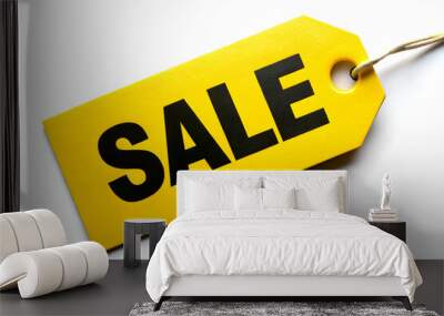 A yellow tag with the word Sale written on it. The tag is hanging from a string. The tag is on a white background Wall mural