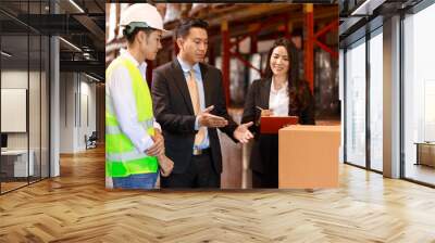 Asian Warehouse manager and male worker as engineer interacting talking checking inventory, manager team working at the storehouse. Wall mural