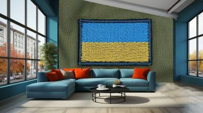 one rectangular blue yellow patch of the Ukrainian flag on the green fabric of the backpack Wall mural