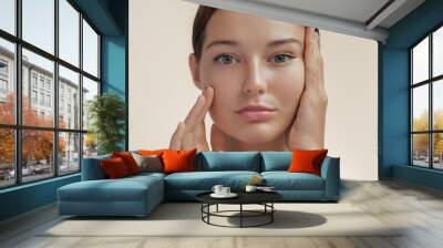 Anti-aging treatment and plastic surgery concept. Beautiful young woman with a hand on her cheek and eye with a serene expression in beauty, skincare, and spa concepts Wall mural