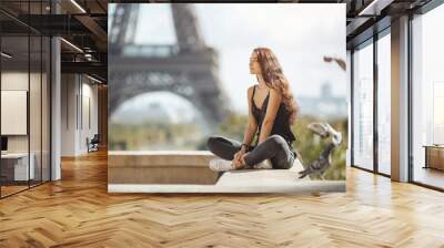 Happy travel woman near the Eiffel tower, Paris. Travel tourist girl on vacation resting happy outdoors. Pigeons symbol of love flying around fliynig Attractive young romantic woman sitting against Wall mural