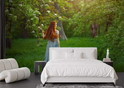 Young beautiful woman in  blooming garden Wall mural