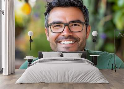 A man with glasses and a green shirt smiling Wall mural