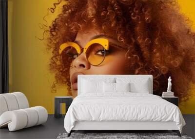 Fashion shooting young afro model in stylish sunglasses on yellow background Wall mural