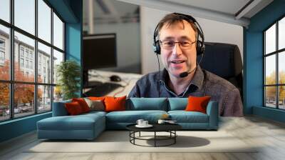 Middle aged mature man in headphones working from call center Wall mural