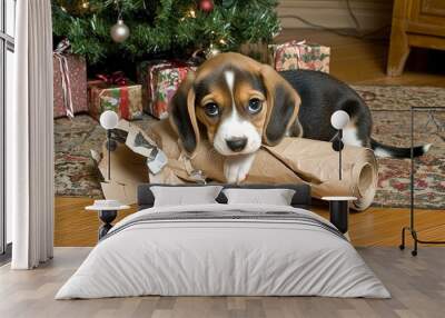 A playful beagle puppy chews on wrapping paper near a decorated Christmas tree surrounded by holiday gifts Wall mural