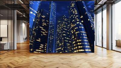 Illuminated skyscrapers towering over the city skyline during a clear night, showcasing modern architecture and urban energy Wall mural