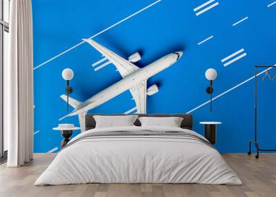 The passenger plane on airport runway and blue background. Top view, Travel and adventure concept Wall mural